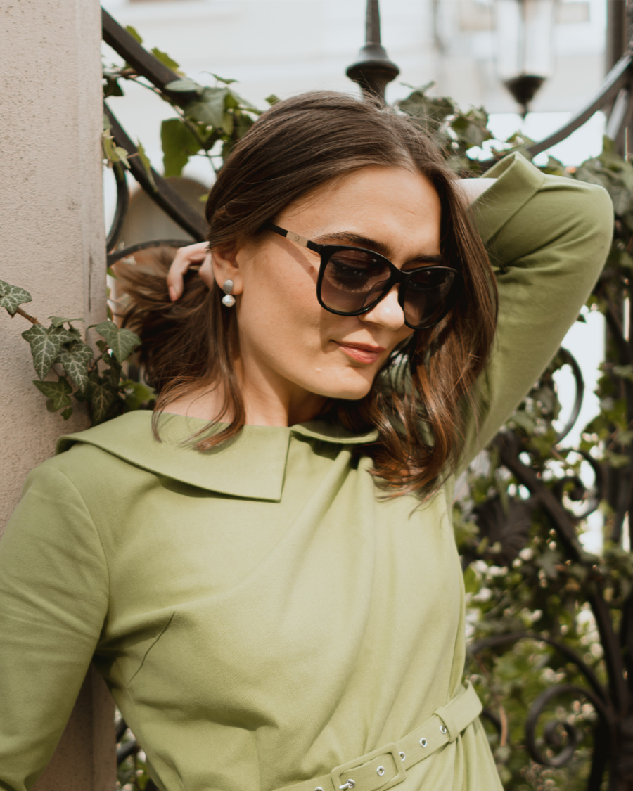 Foto de modelo usando vestido verde e brincos de prata