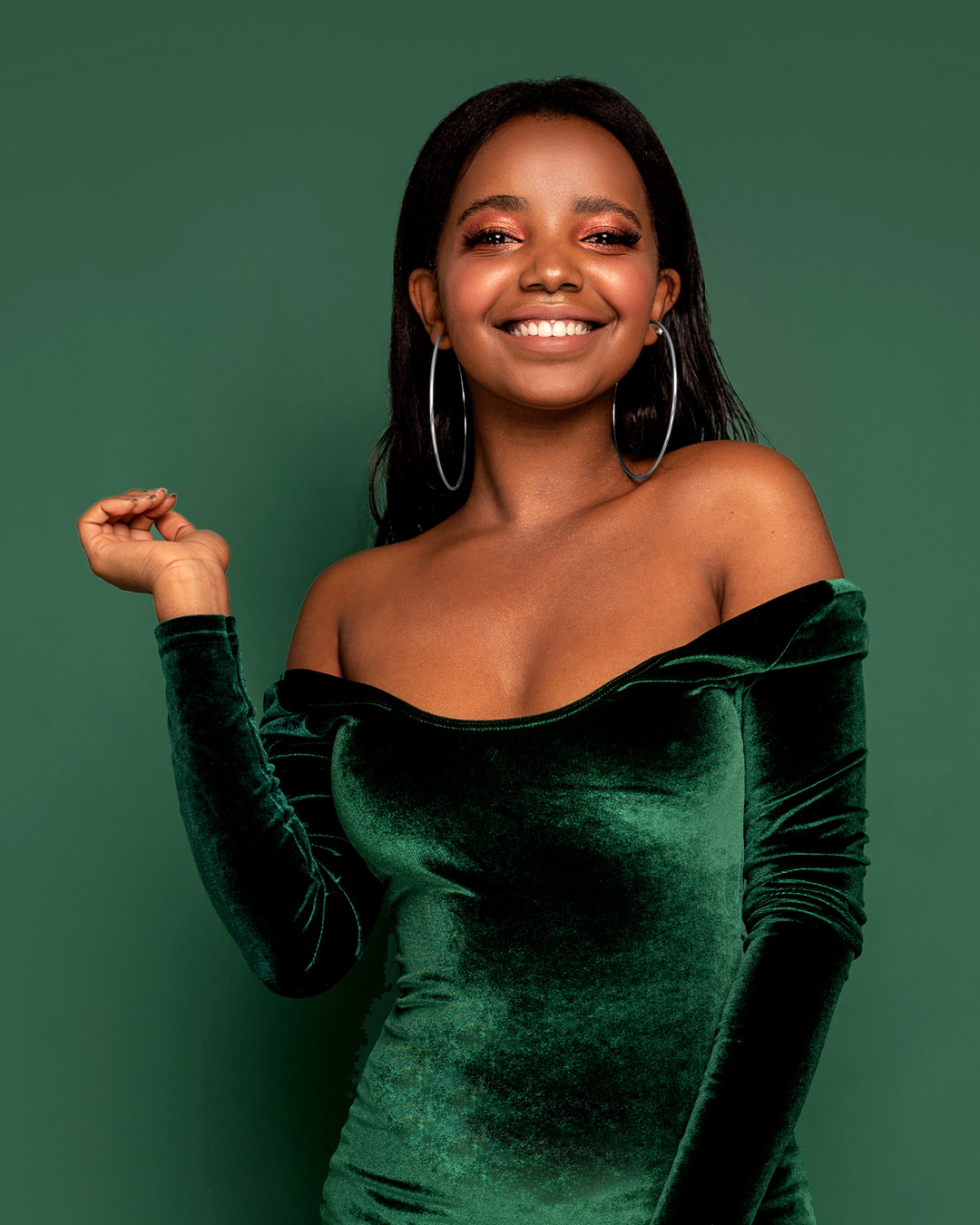 Foto de mulher de vestido verde em frente a fundo verde.