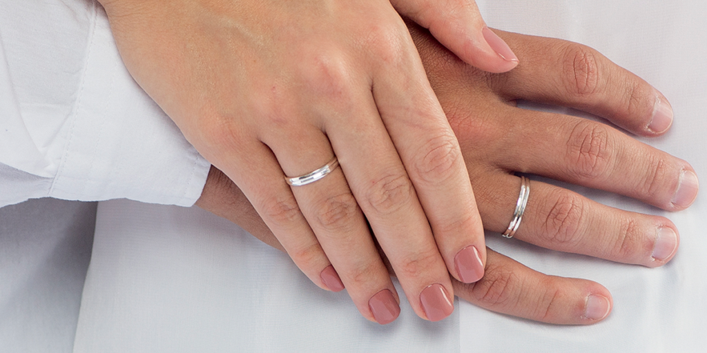 Duas mãos com alianças